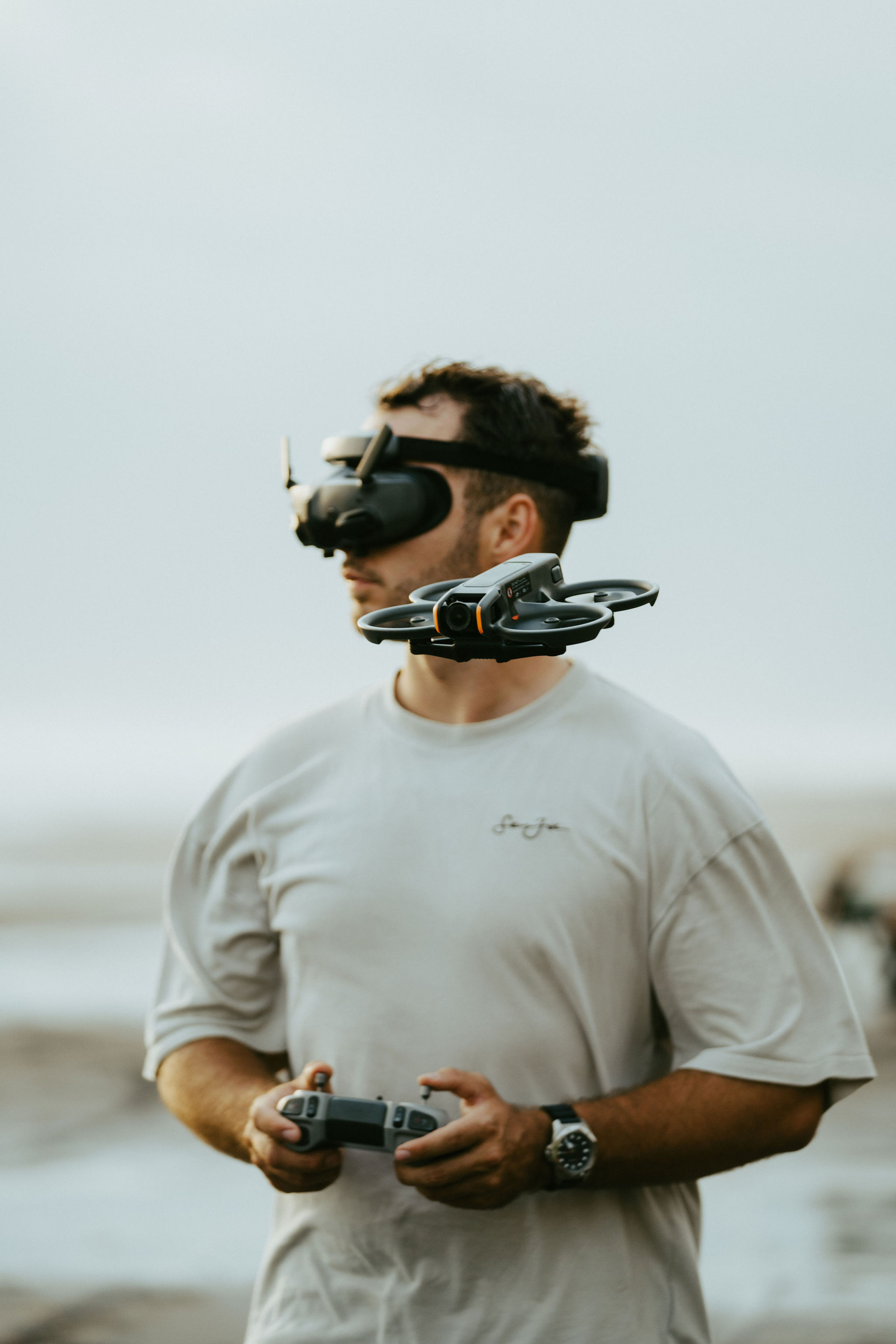 Ben flying an FPV drone with goggles on the beach