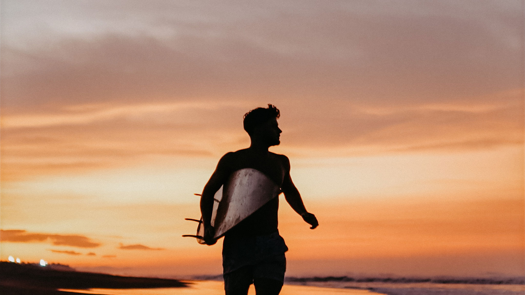 Surfer with his board at sunset