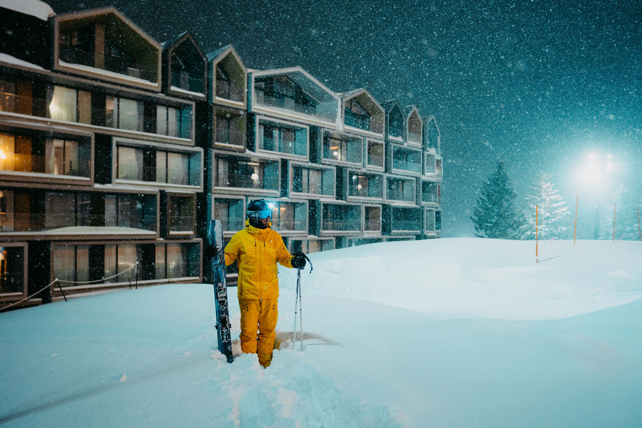 Snowboarder carving a deep powder turn through Hokkaido trees